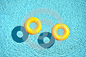 Yellow pool float, pool ring in cool blue refreshing blue pool