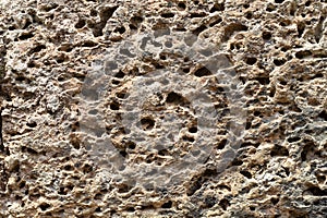 Yellow porous stone texture photo. Natural stone background. Weathered rock relief. Old grunge stone