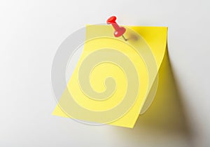 Yellow post-it note with red pushpin