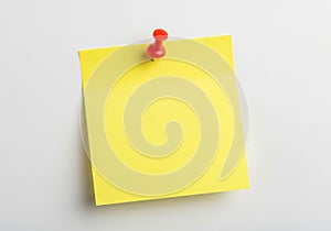 Yellow post-it note with red pushpin