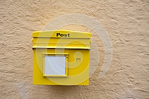 Yellow postbox on the wall