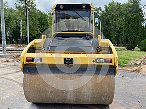 Yellow powerful large new modern road roller for asphalt paving and road repair at construction site. Construction machinery