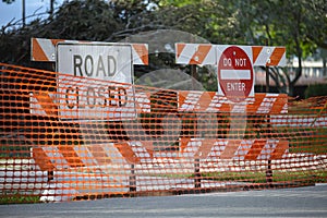 Yellow protective fence barrier at street construction site. Warning road sign about utility work