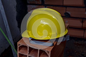 Yellow protective helmet on pile of red bricks photo