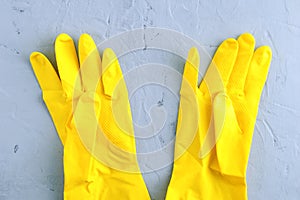 Yellow protective rubber gloves on gray concrete background