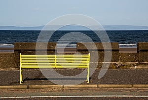 Yellow Public Bench at a Seafront Location