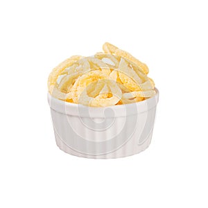 Yellow puff corn sticks ring in white ceramics bowl isolated on white background.