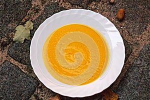 yellow pumpkin cream soup in white plate Halloween, autumn comfort food