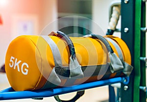 Yellow punching bag of five kilograms on a stand in a gym. Training equipment for sport. Close-up