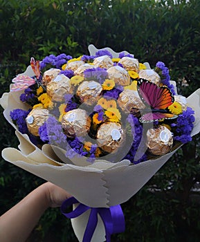 A yellow and purple flower bouquet with chocolate for valentine's celebrate