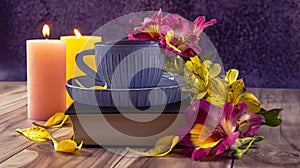 Yellow and purple flowers of alstroemeria, blue cup of coffee. Romantic composition with candles and a book.