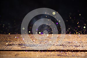 Yellow And Purple Glitter Lights Background. Vintage Sparkle Bokeh With Selective Focus. Defocused. On Wood Texture.