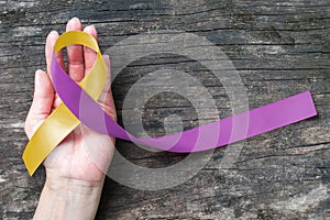 Yellow Purple ribbon raising awareness on RA disease and World Autoimmune Arthritis Day photo