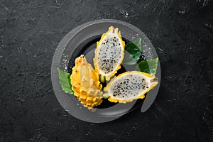 Yellow Pytahya on a black background. Fruit Dragon. Tropical Fruits. Top view.