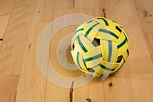 Yellow rattan ball with green stripes
