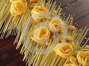 Yellow raw pasta on rustic background. Different types of pasta