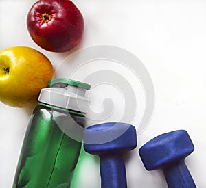 Yellow and red apples, a green water bottle and two blue dumbbells on a white background.