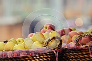 Yellow and red apples in wooden baskets.