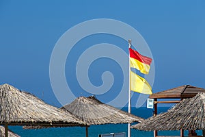 Yellow-red and yellow beach warning flags on the hotel plage. International classification, lifeguard protected area. Be careful
