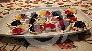 yellow, red and black fish caviar dish on the table of chrismast holiday