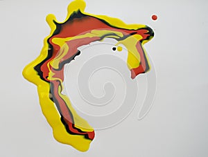 yellow  red  and black paint is spilled on a piece of paper