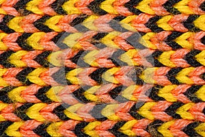 Yellow, red and black synthetic knitted fabric texture