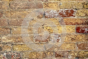 Yellow and red brick wall surface detail of Venetian building.