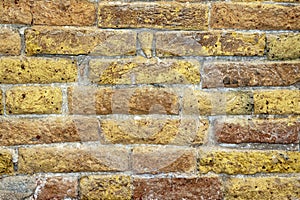 Yellow and red brick wall surface detail of Venetian building.