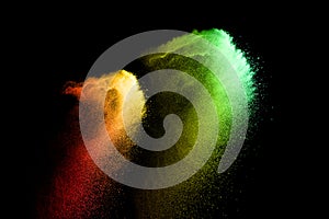 Yellow red green powder explosion cloud isolated on black background.