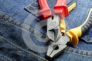Yellow red nippers on a jeans background working tool grunge style pair pliers design base
