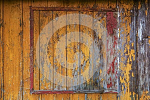 Yellow , red and orange paint on old wooden house wall