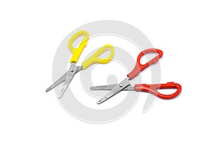 Yellow and red plastic scissors isolated on white.