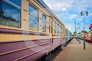 Yellow-red train carriage, old carriage on the platform, side view of the train carriage, windows on the train