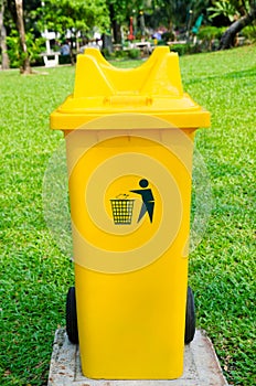 Yellow refuse bin in park