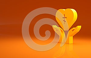 Yellow Religious cross in the heart inside icon isolated on orange background. Love of God, Catholic and Christian