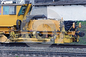 Yellow repair locomotive stands on the rails of the railway