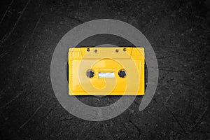 Yellow retro Cassette tape over blackboard. top view.