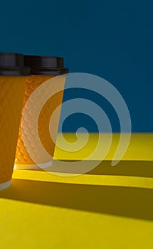 Yellow ribbed paper cup with plastic lid for takeaway beverage in fast food restaurants. A cup of coffee, cocoa, tea from a street