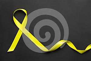 Yellow ribbon on a black background.World suicide prevention day.