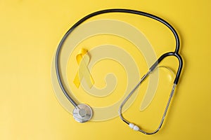 Yellow Ribbon and Stethoscope on yellow background for supporting people living and illness. July Sarcoma cancer, Suicide