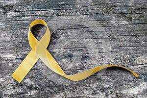 Yellow ribbon symbolic color for Sarcoma Bone cancer awareness and suicide prevention on aged wood isolated with clipping path