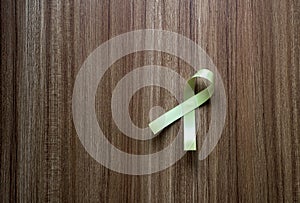 Yellow ribbon on wooden background,Suicide prevention,Cancer disease awareness concept,Top view and copy space for text