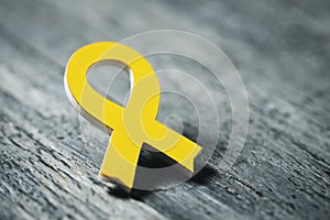 Yellow ribbon on a wooden surface