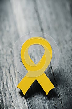 Yellow ribbon on a wooden surface photo