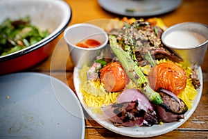 Yellow rice with meat. roasted tomato and onion toppings