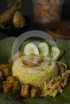 Yellow rice or turmeric rice on banana leaf with other dish