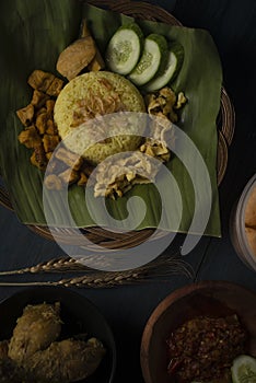 Yellow rice or turmeric rice on banana leaf with other dish