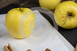 yellow ripe apple with cinnamon on the table