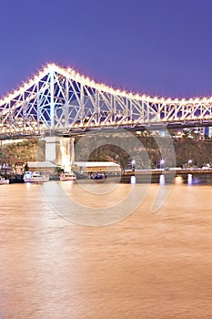 Yellow river and a bridge with lights at night