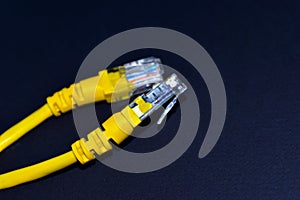 Yellow RJ-45 or ethernet internet cable on black background